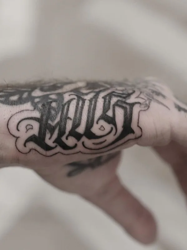 black lettering 纹身 在 back of hand #41593 | 纹身师 Niorkz