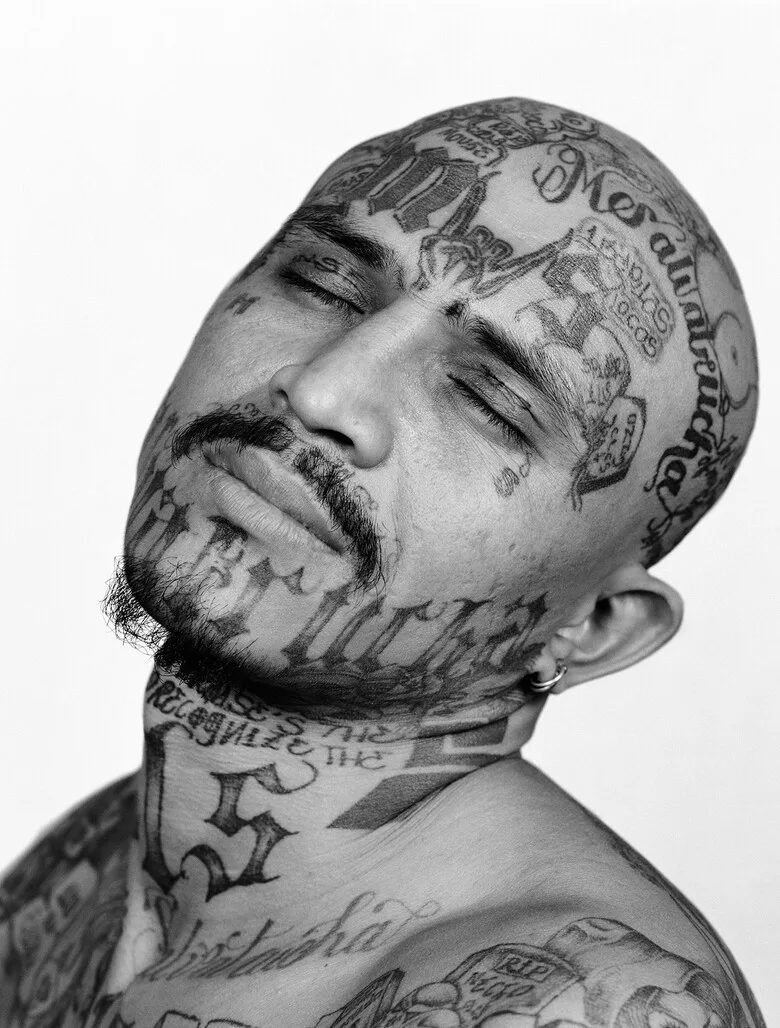 An MS-13 gang member with tattoos on his face and neck, including inscriptions and symbols indicating his status and affiliation. Photo: tatpix.ru (CC BY-SA 2.0).