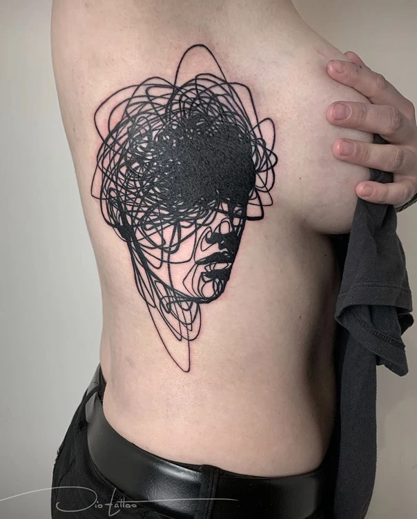 Abstract Face tattoo on Ribcage