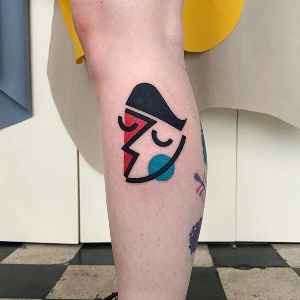 Abstract Face tattoo on Calf