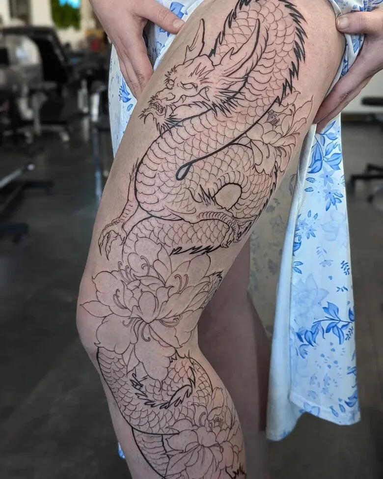 Tatouage de dragon sur la cuisse avec fleurs