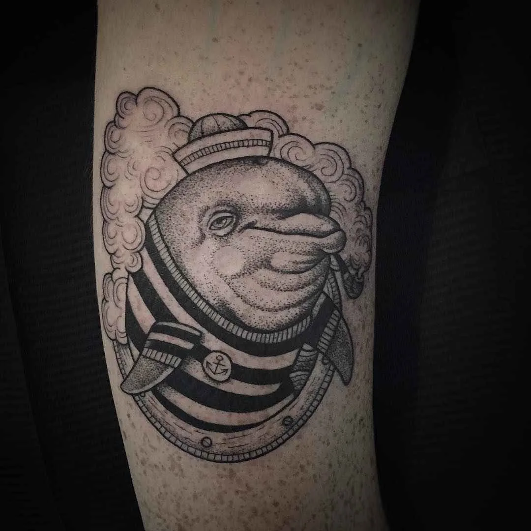 A black and grey sketch-style tattoo of a dolphin wearing a sailor's outfit and smoking a pipe, rendered with fine linework.