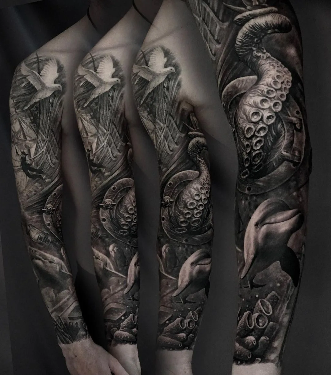 A full sleeve tattoo in black and grey featuring a nautical composition with dolphins, an anchor, an octopus, a ship, and doves.