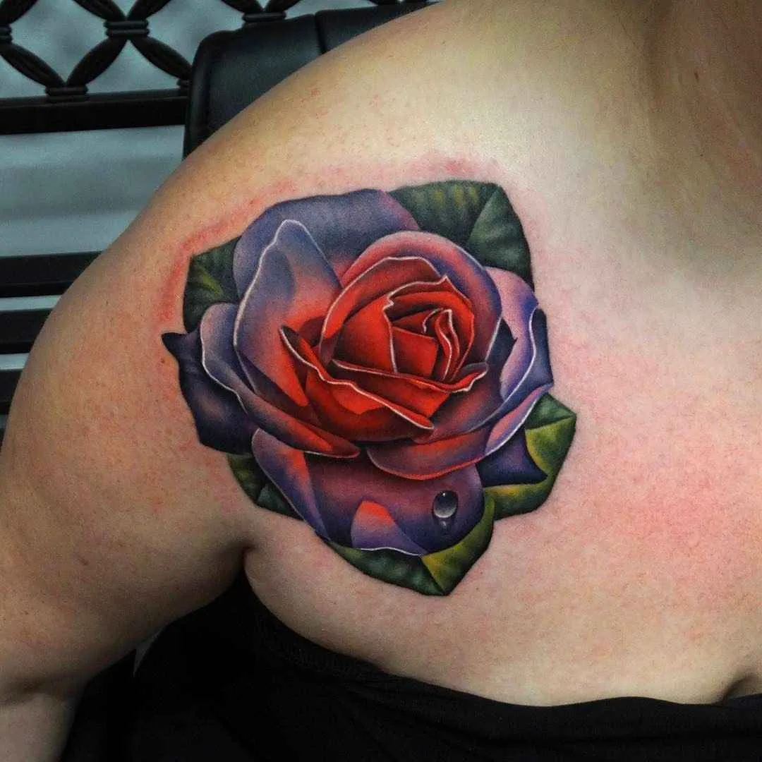 Ein realistisches Rosen-Tattoo auf der Schulter mit detaillierten Schattierungen, leuchtend roten und violetten Tönen und einem gemalten Wassertropfen.