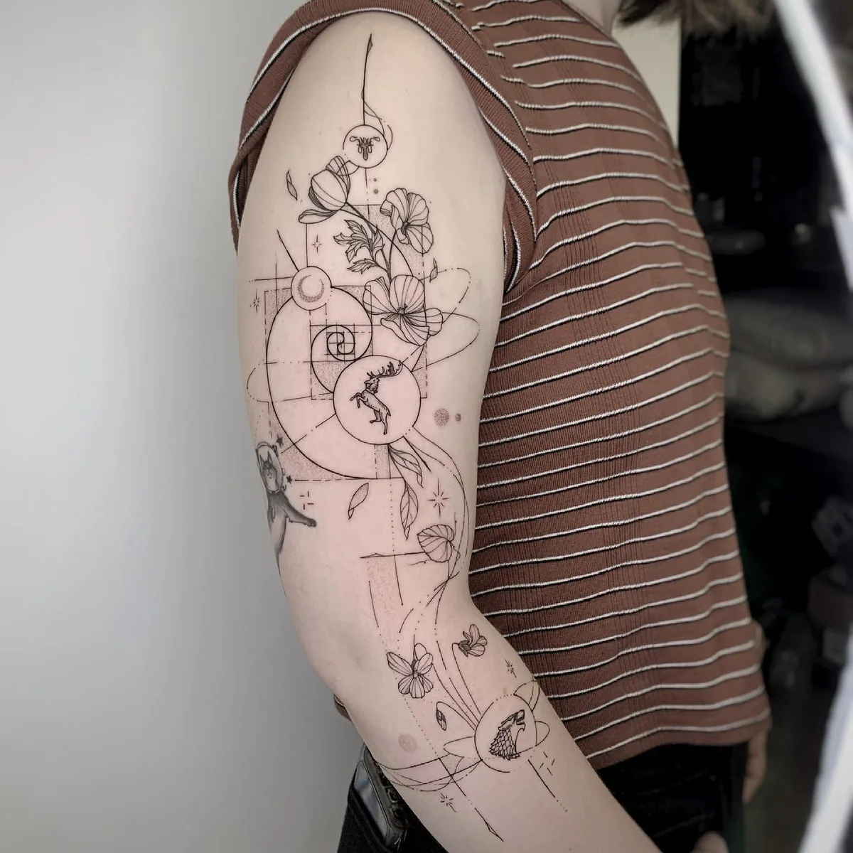 Botanical and geometric shapes in a tattoo on the arm
