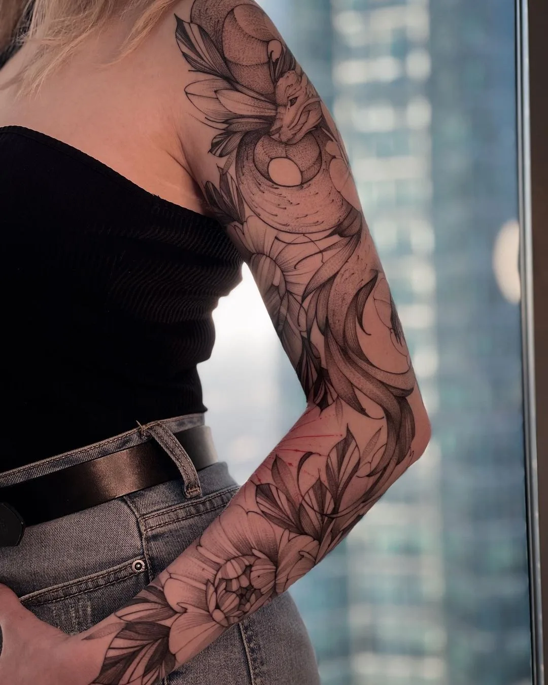 Tatuagem no braço com flores e dragão para uma menina