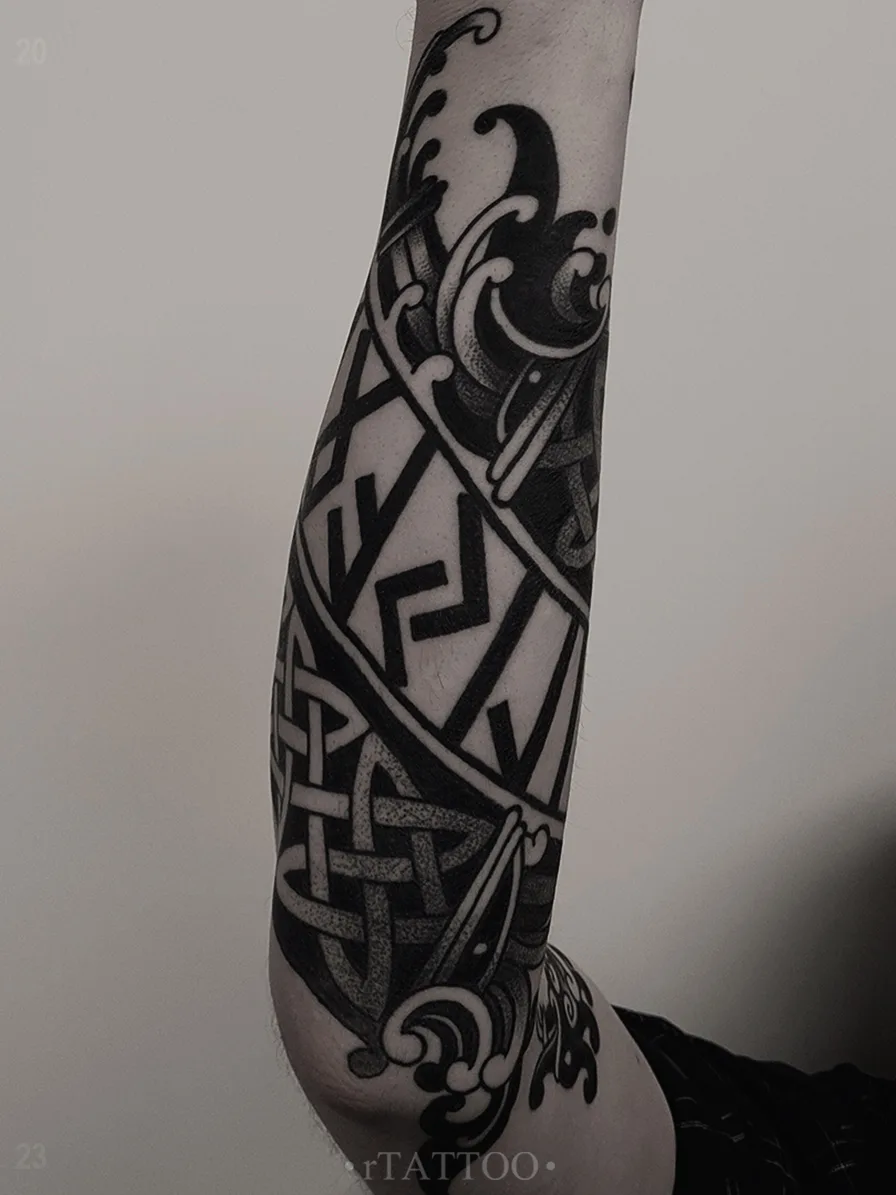 Ein Blackwork-Tattoo auf dem Unterarm mit keltischen Knoten, Runen und stilisierten Wellen.