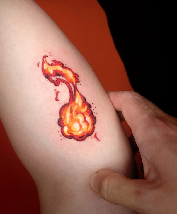 Cartoon Fire tattoo on Outer arm