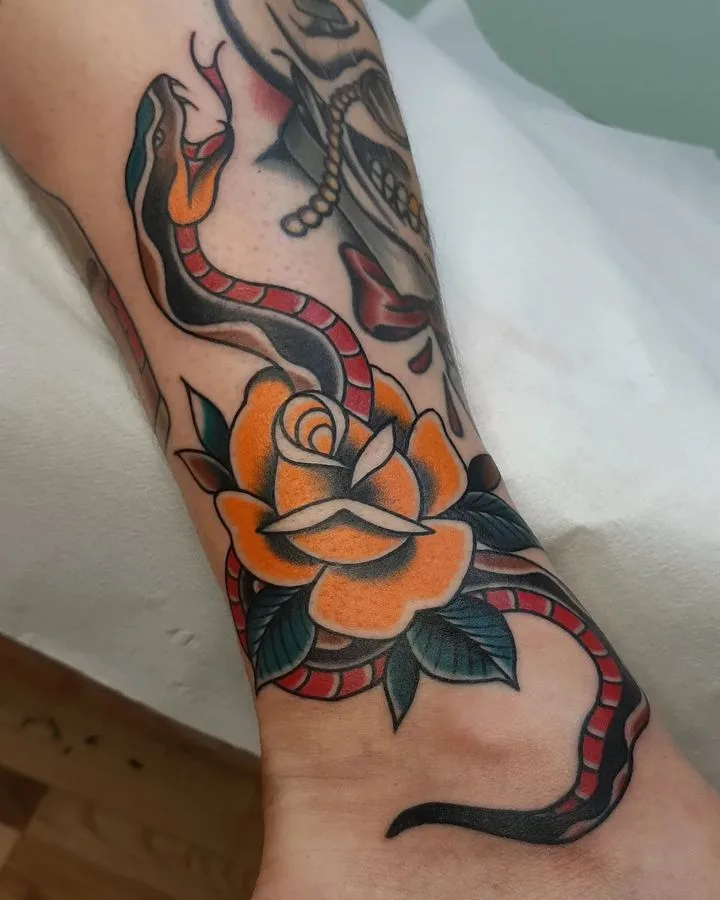 A traditional-style tattoo featuring a snake coiled around a rose, rendered in vibrant colours with bold outlines and flat shading.
