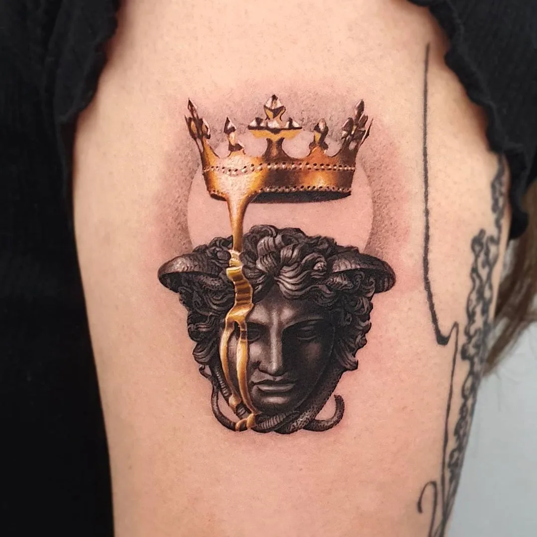 Tatuaggio dettagliato della testa di Medusa con corona dorata e ombreggiature realistiche, realizzato da jiro_painter.