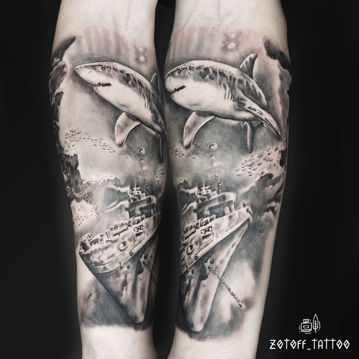 A detailed black and grey realistic tattoo depicting sharks swimming above a sunken shipwreck, with strong shading and atmospheric depth.