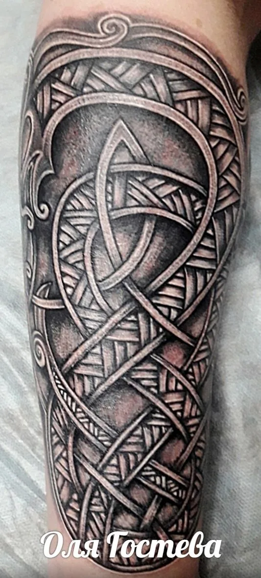 Ein Tattoo mit keltischen Flechtmustern und geometrischen Formen, das an eine Triskele erinnert.