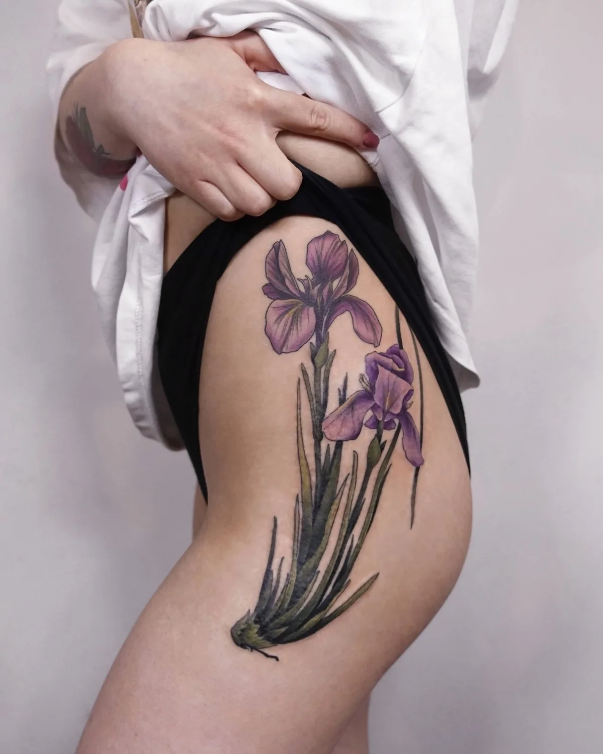 Tatuagem de iris na coxa do mestre Olga Nekrasova