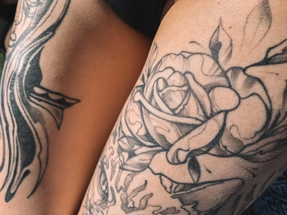 Ein Schwarz-Grau-Rosen-Tattoo mit detaillierter Linienführung auf dem Unterarm.