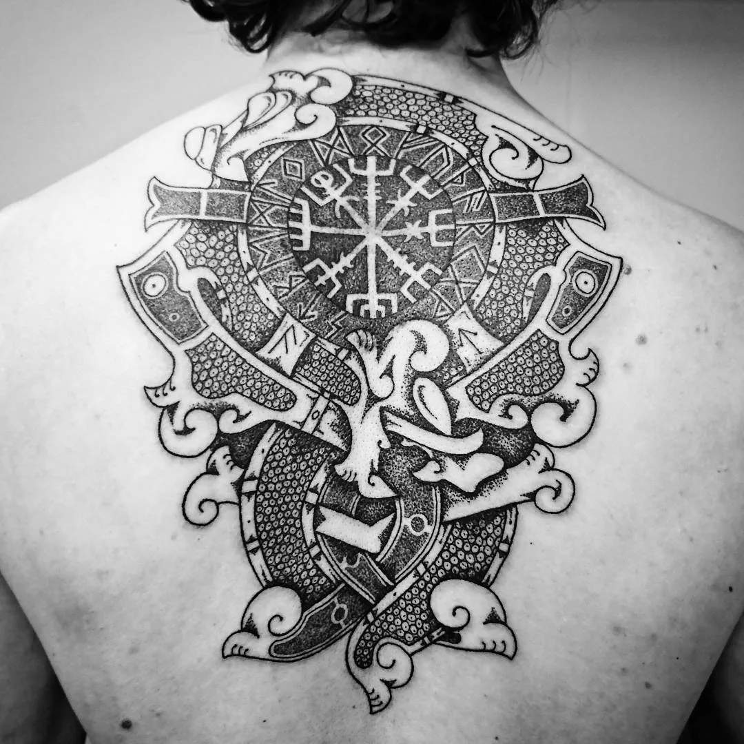 Grand tatouage blackwork représentant une boussole viking et des entrelacs complexes, couvrant une grande partie du haut du dos.