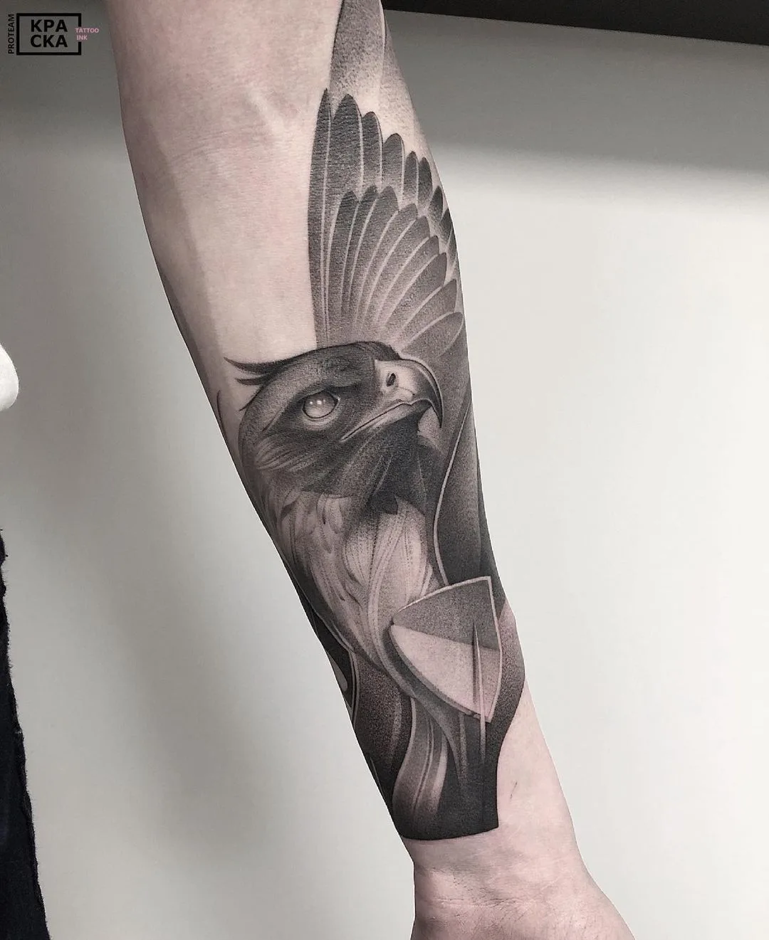Realistic black and grey tattoo of an eagle with outstretched wings, featuring highly detailed feather work.