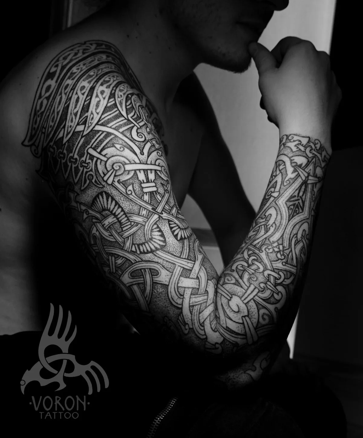 Ein vollständig mit keltischen Flechtmustern und geometrischen Ornamenten bedeckter Arm in Blackwork-Technik.