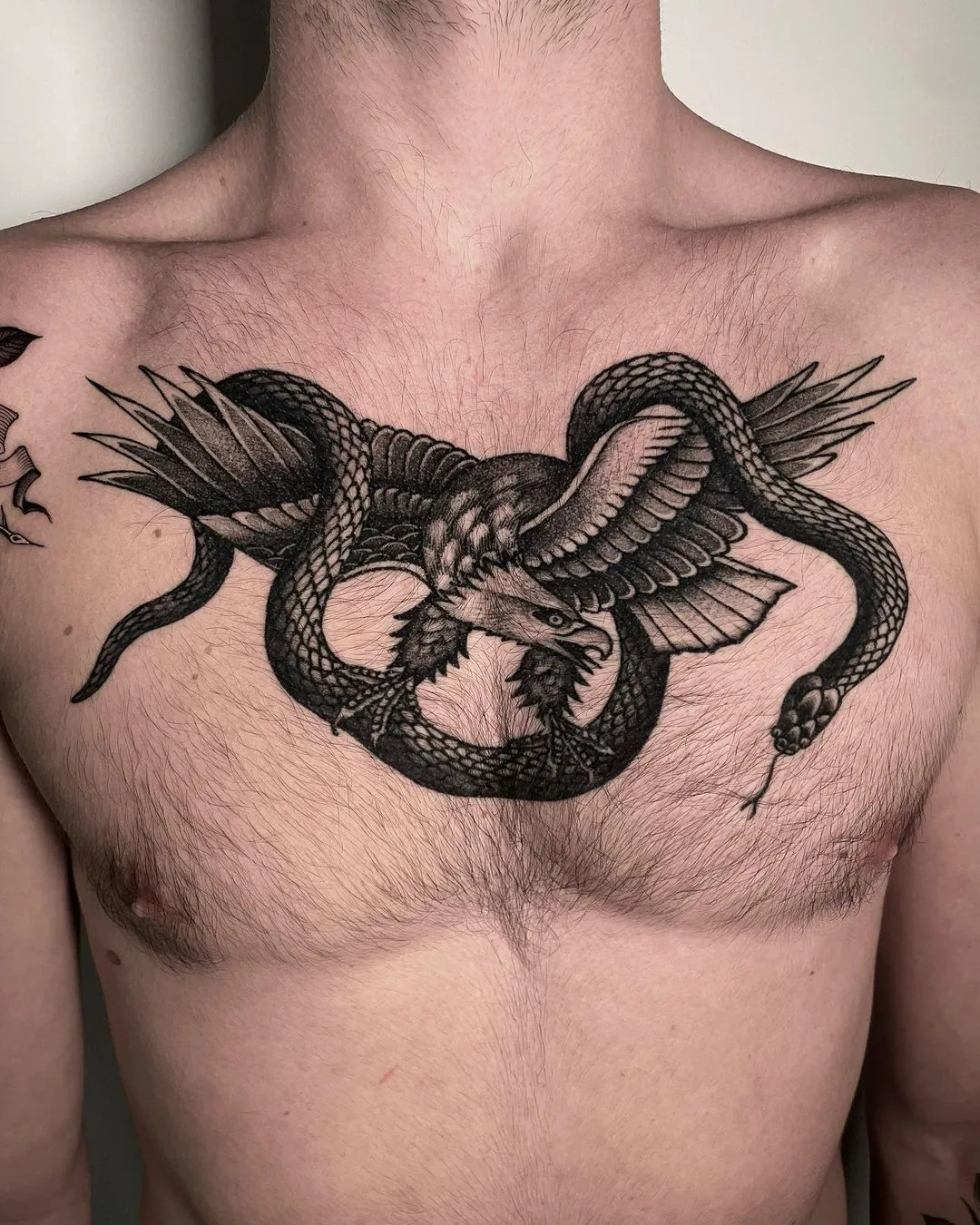 Blackwork tattoo of an eagle and snake intertwined, rendered in detailed black ink with no color fills.