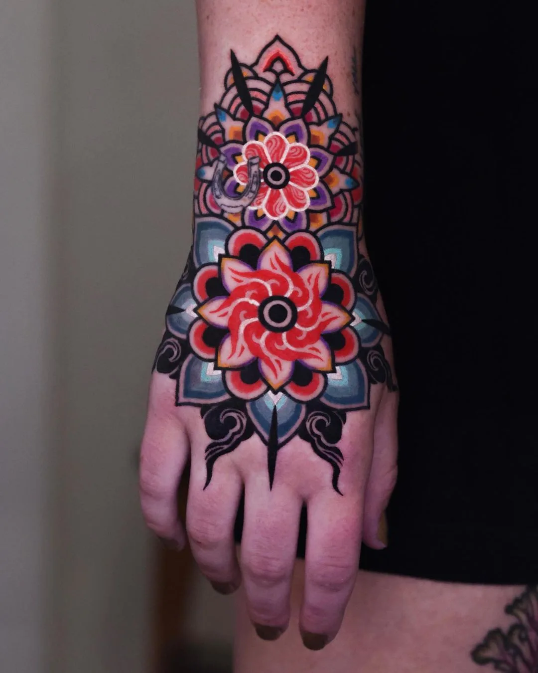 Tatuaggio mandala colorato in Dancheong sulla mano da Kiwa
