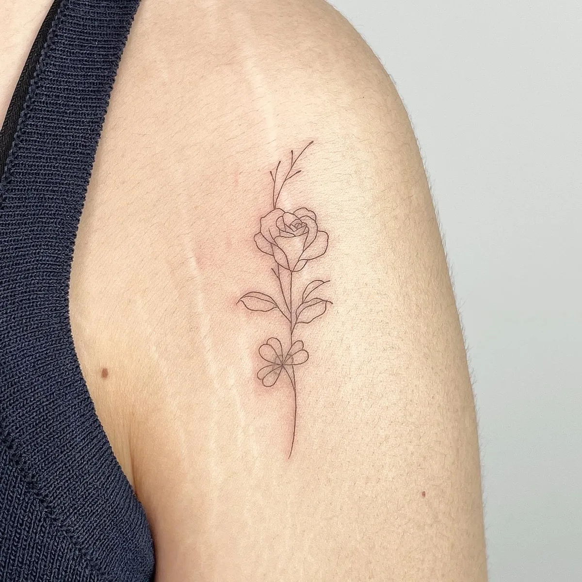 Fine line flower tattoo by Sop Tattoo