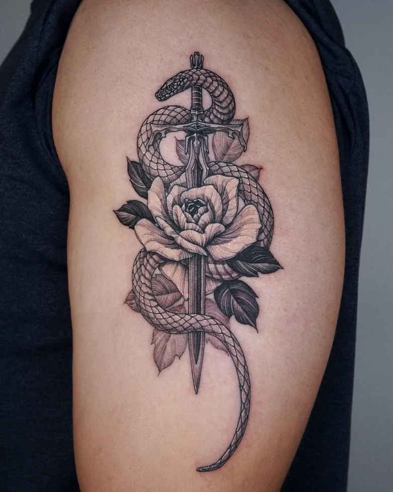 Tatuaggio di serpente e spada realizzato da Intat