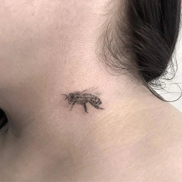 Fineline Bee tattoo on Back of neck