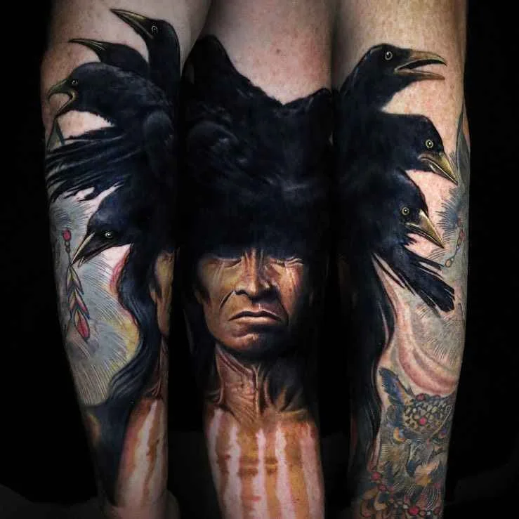 A detailed black and grey tattoo depicting a woman figure with large crow wings spread behind her and a crow perched on her back.