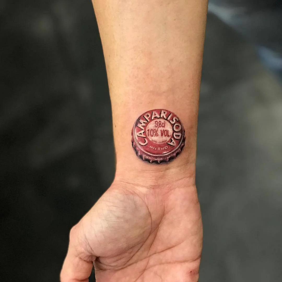 Tatuagem artista Alberto Marzari, cor tatuagem pequena realista, minimalismo, tampinha de garrafa de cerveja Campari | Roma, Itália 