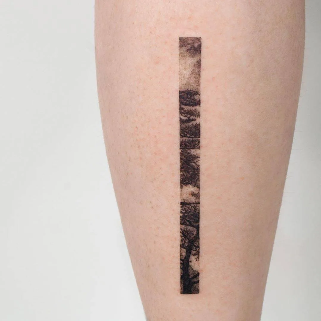A vertical blackwork tattoo on the forearm featuring a series of landscape scenes resembling a film strip.
