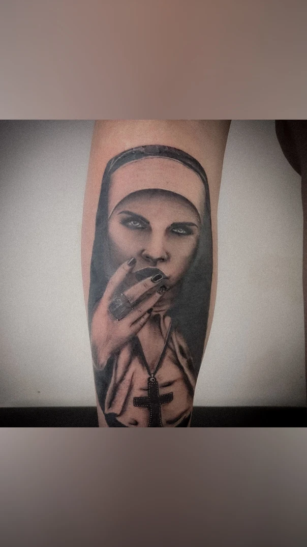 Realism Nun, Cross tattoo on Calf