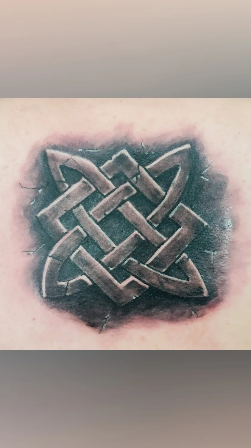 Ein keltisches Knotenmuster-Tattoo mit verwitterter Steinoptik und dreidimensionalem Schatteneffekt.
