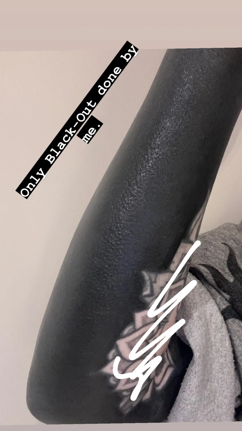 A full blackout tattoo covering the forearm.