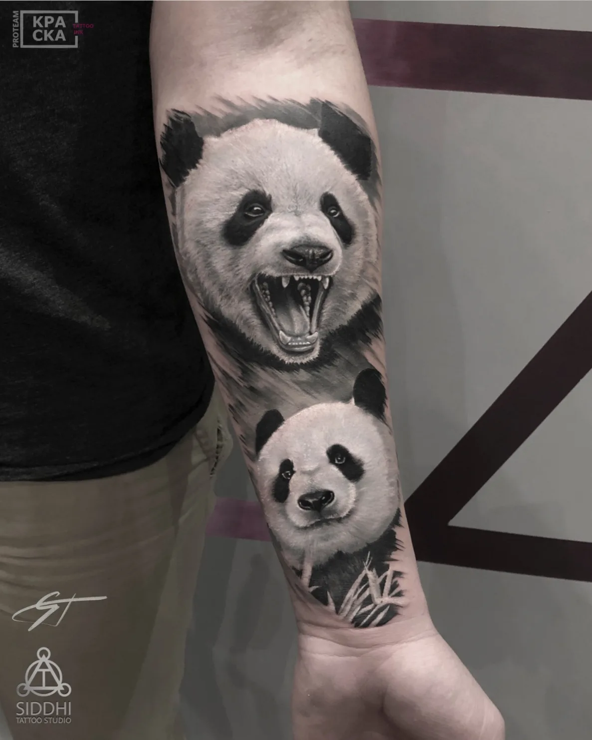A detailed black and grey tattoo of two pandas, one with an open mouth and the other with a closed mouth.