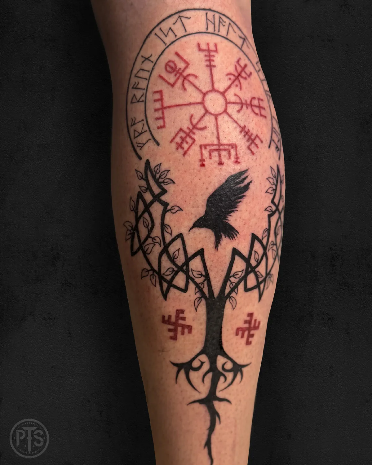 Tatouage blackwork représentant une boussole, un arbre et un corbeau avec entrelacs celtiques et runes.