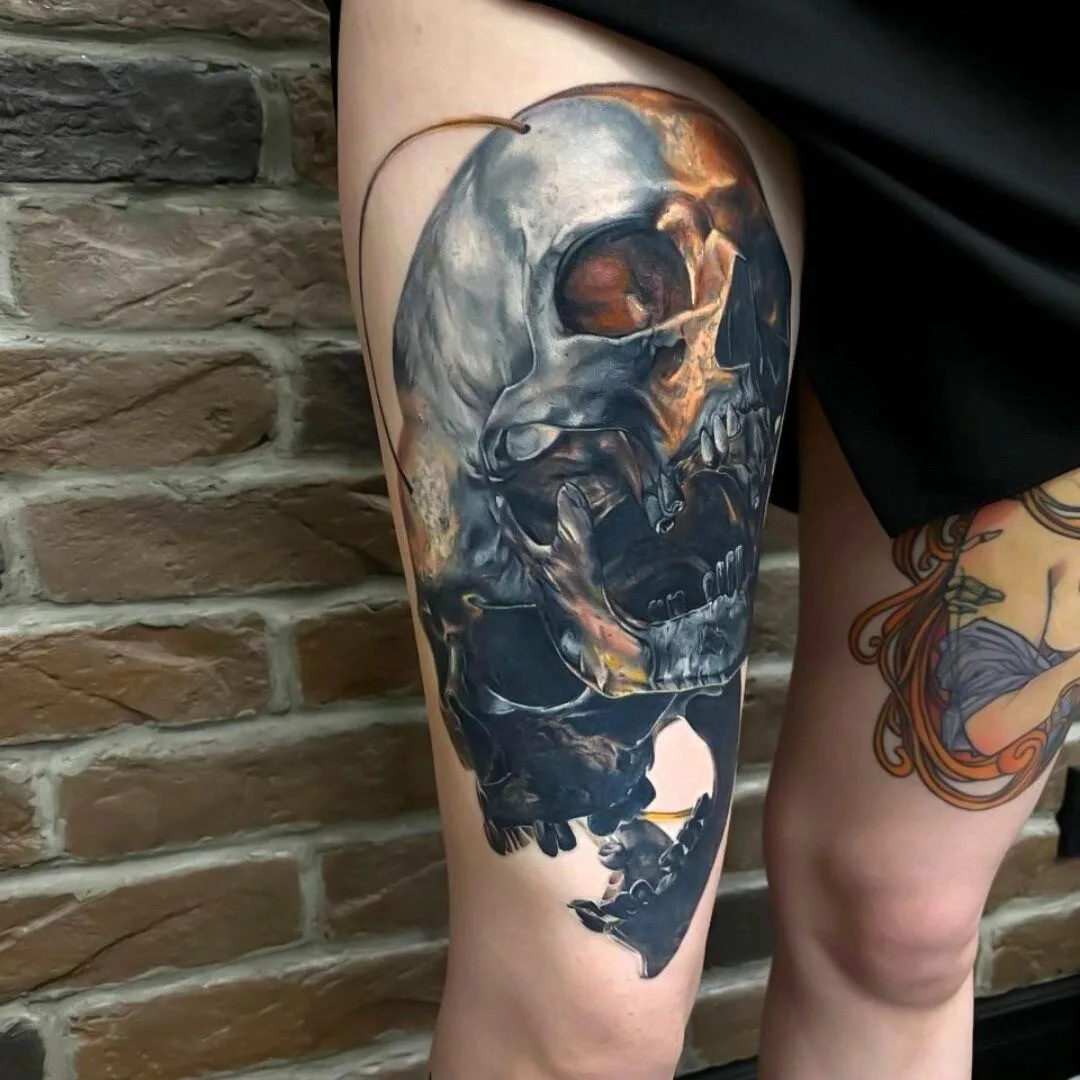 A detailed, realistic black and grey skull tattoo with rich shading and a dark aesthetic.