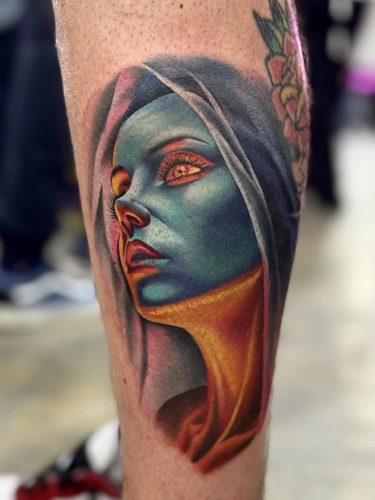 Color realism portrait of a hooded woman in turquoise and orange tones on the lower leg