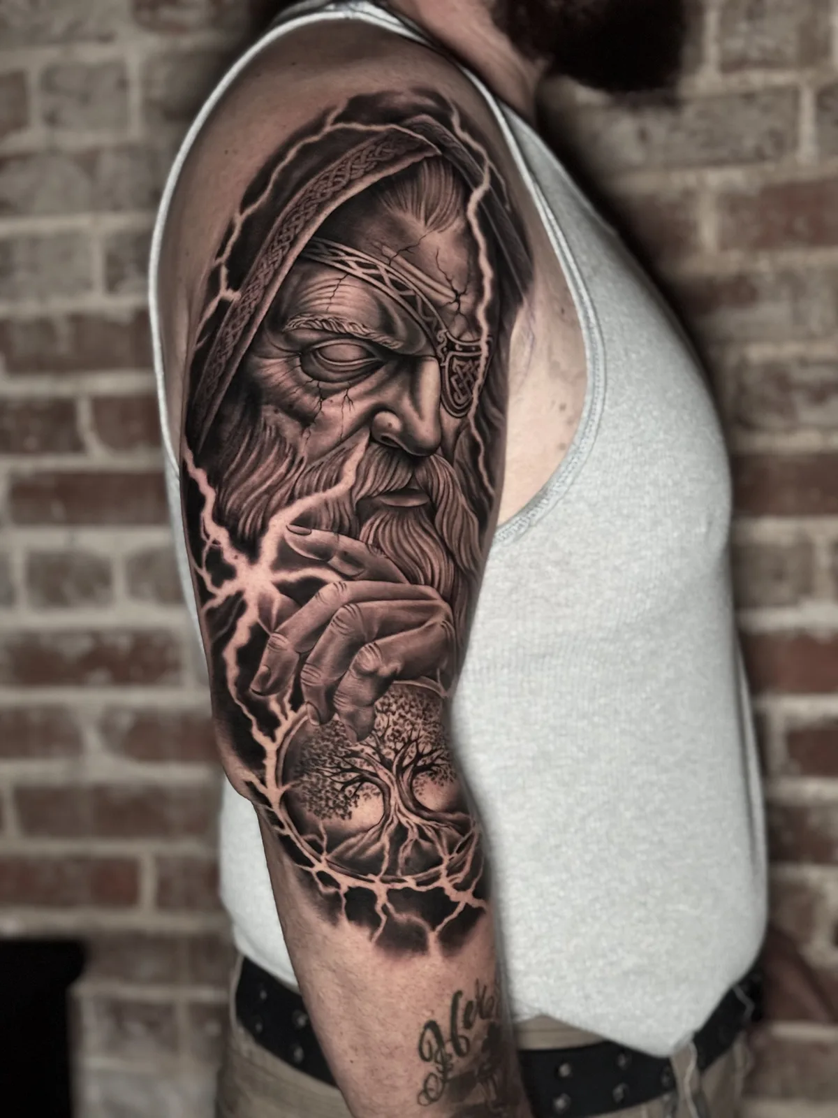 Black and grey half sleeve of an old wizard-like god with lightning and a tree of life
