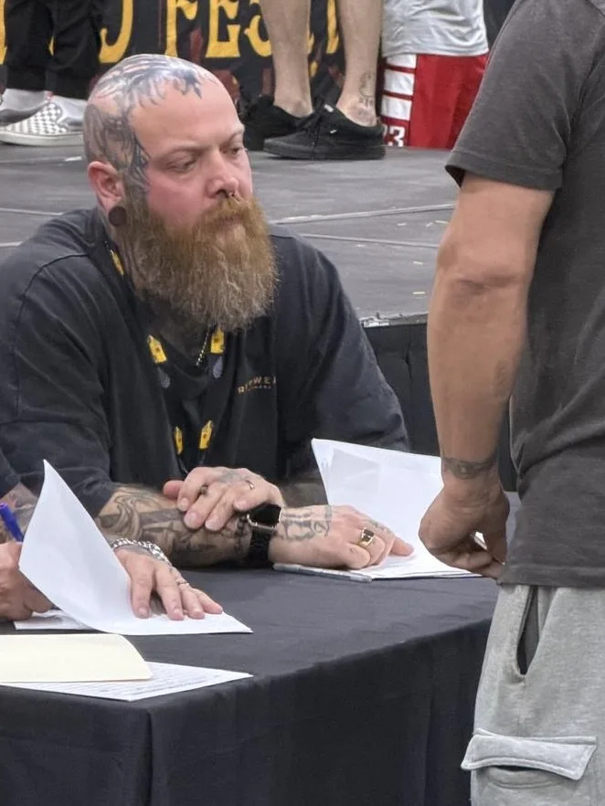 Eike Schumacher judging tattoos at a convention table