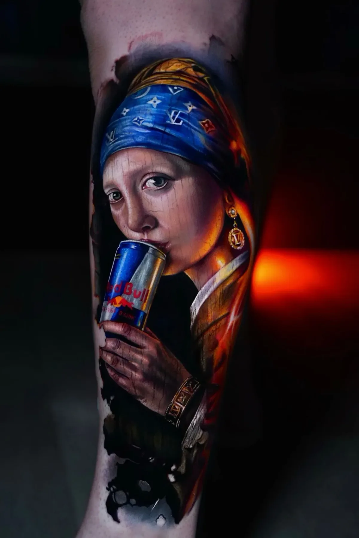 A hyperrealistic colour tattoo of a young woman based on Vermeer's Girl with a Pearl Earring; she wears a blue Louis Vuitton-patterned headscarf and holds a Red Bull can to her lips, with abstract dark shapes at the base of the composition.