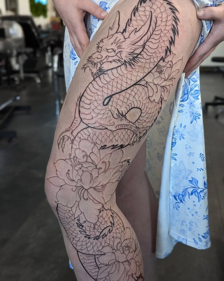 Dragon tattoo on thigh with flowers